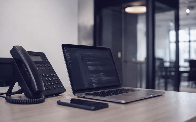 Telefon und Notebook auf einem Schreibtisch